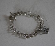 bracciale argentato con charms fiore e chiusura a t