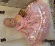 Vestitino rosa in organza, seta, pizzo macrame'. È completo di cappellino, scarpine e fascetta per capelli.