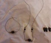 Gioielli perle nere e motivi in metallo
